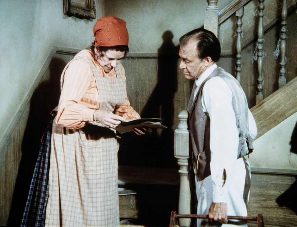 Harriet Oleson (Katherine MacGregor, l.) zeigt ihrem Mann Nels (Richard Bull, r.) alte Papiere, die sie unter einer Treppenstufe gefunden hat. - Bildquelle: Worldvision
