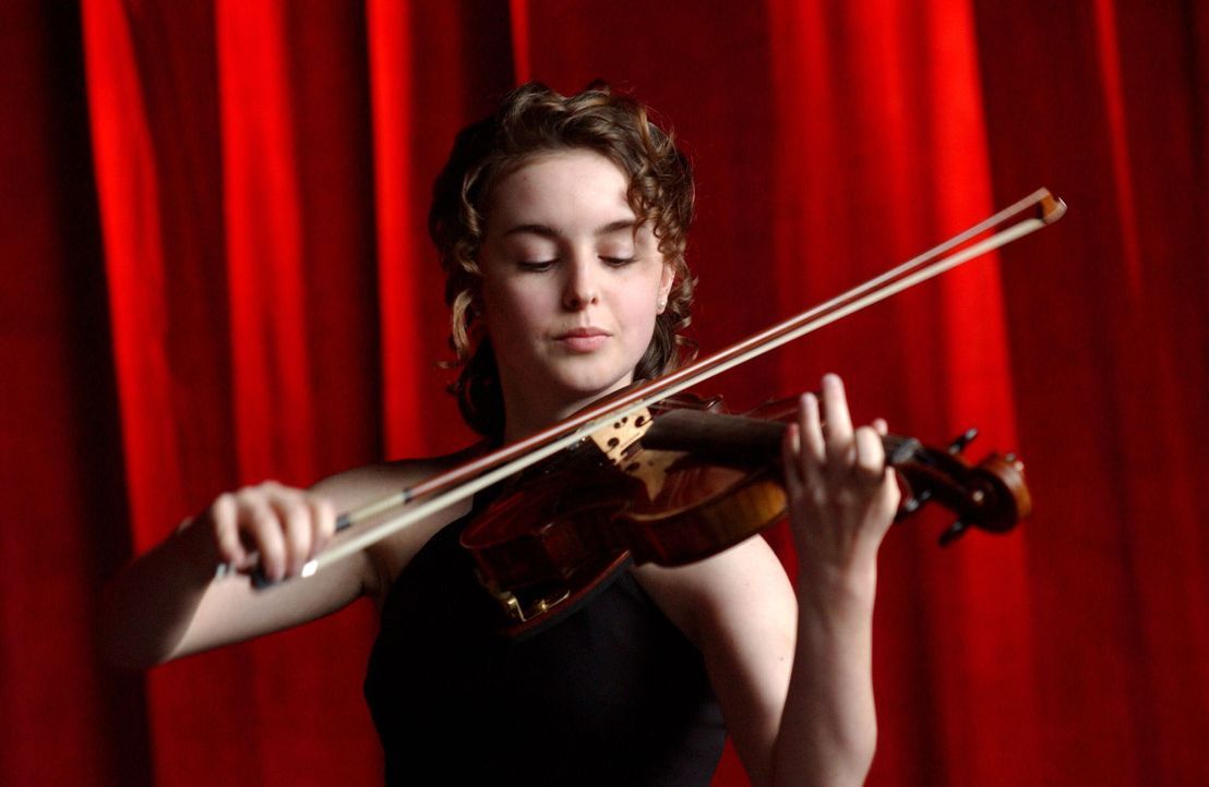 Mit Hingabe spielt die erst 14-jährige Natasha Tzetcovich (Elizabeth Rice) die Violine. - Bildquelle: Warner Bros. Entertainment Inc.