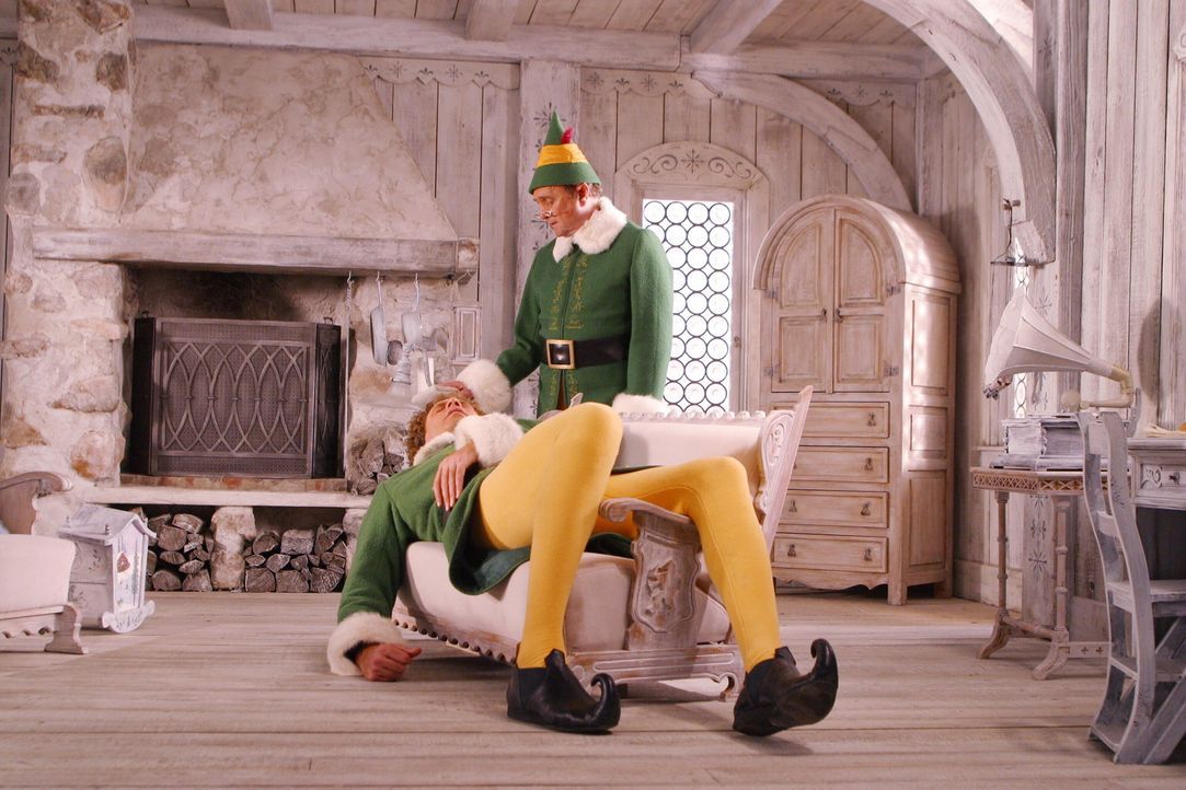 Papa Elf (Bob Newhart, r.) zieht Buddy (Will Ferrell, l.) auf. Eines Tages merkt der große Buddy, dass er nicht zu den Elfen passt und möchte desh... - Bildquelle: Warner Bros. Television