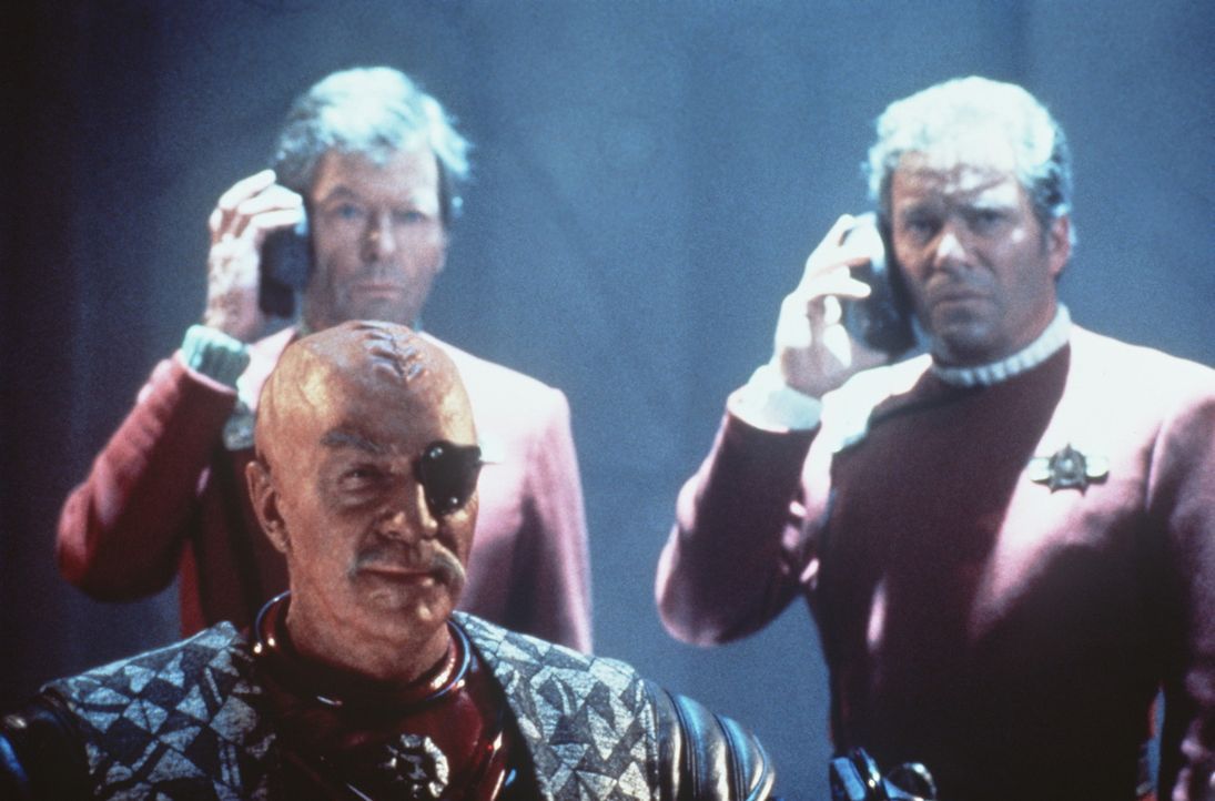 McCoy (DeForest Kelley, hinten l.) und Kirk (William Shatner, hinten r.) erhalten schlechte Nachrichten - doch General Chang (Christopher Plummer, v... - Bildquelle: Paramount Pictures