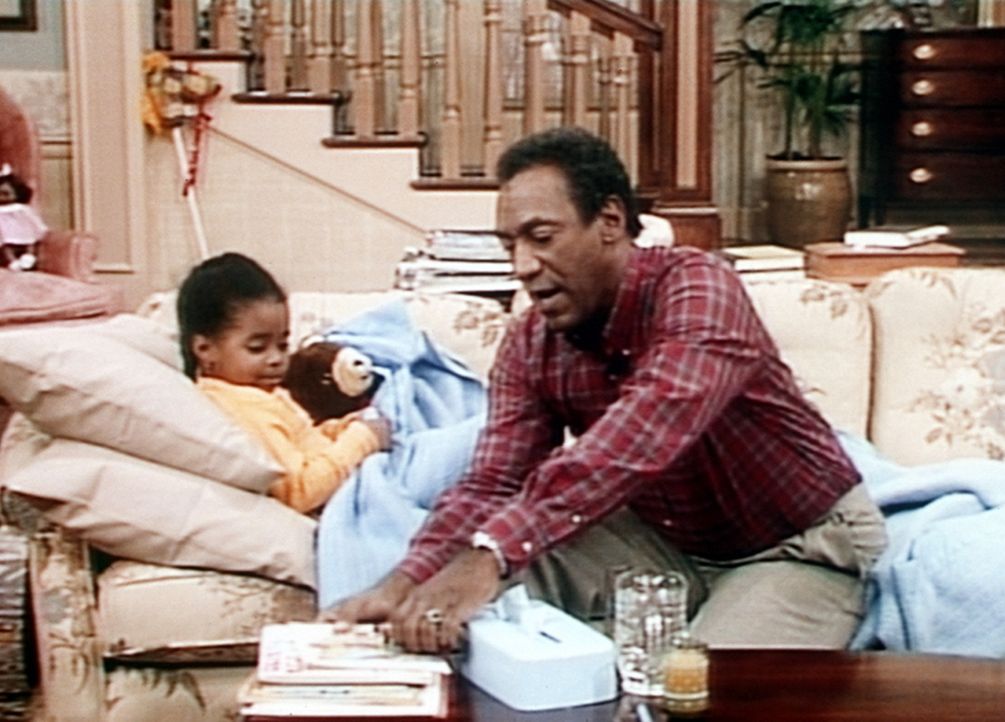 Rudy (Keshia Knight Pulliam, l.) ist krank und wird von Cliff (Bill Cosby, r.) im Wohnzimmer auf die Couch gebettet. - Bildquelle: Viacom