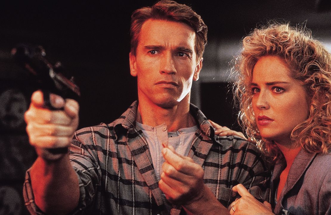 Der Bauarbeiter Douglas Quaid (Arnold Schwarzenegger, l.) führt eigentlich ein zufriedenes Leben mit seiner attraktiven Frau Lori (Sharon Stone, r.)... - Bildquelle: 1990 STUDIOCANAL. All Rights Reserved.