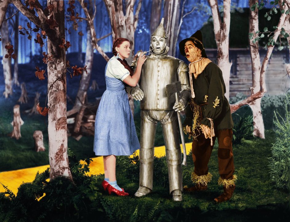 Der Zinnmann (Jack Haley, M.) hätte so gerne ein Herz unter seiner Rüstung. Dorothy (Judy Garland, l.) und die Vogelscheuche (Ray Bolger, r.) tröste... - Bildquelle: Warner Bros.