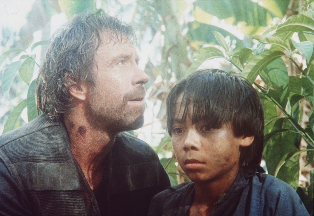 Braddock (Chuck Norris, l.) flieht mit seinem Sohn Van (Roland Harrah III., r.) durch den Dschungel ... - Bildquelle: Cannon Films