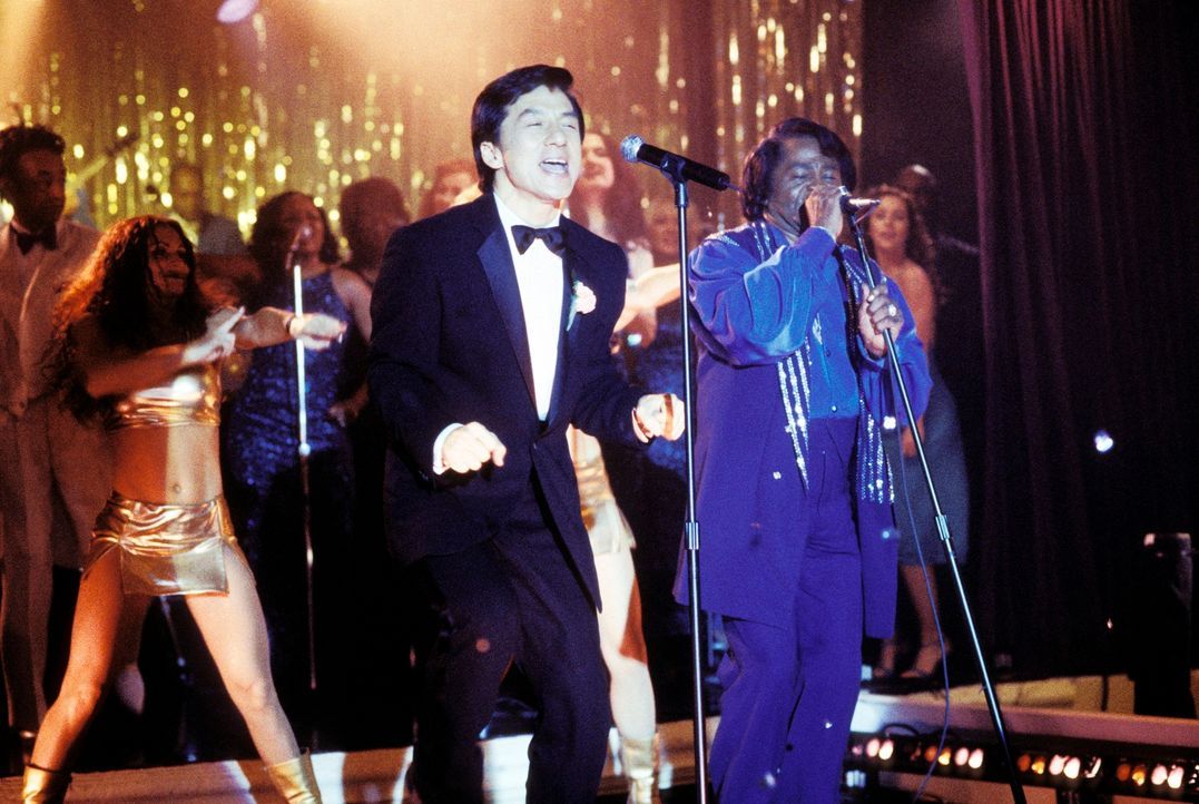 Kaum hat Jimmy (Jackie Chan, l.) den Anzug seines im Koma liegenden Chefs an, da befindet er sich auch schon auf der Bühne, wo er die Vertretung von... - Bildquelle: TM &   2002 DreamWorks LLC. All Rights Reserved