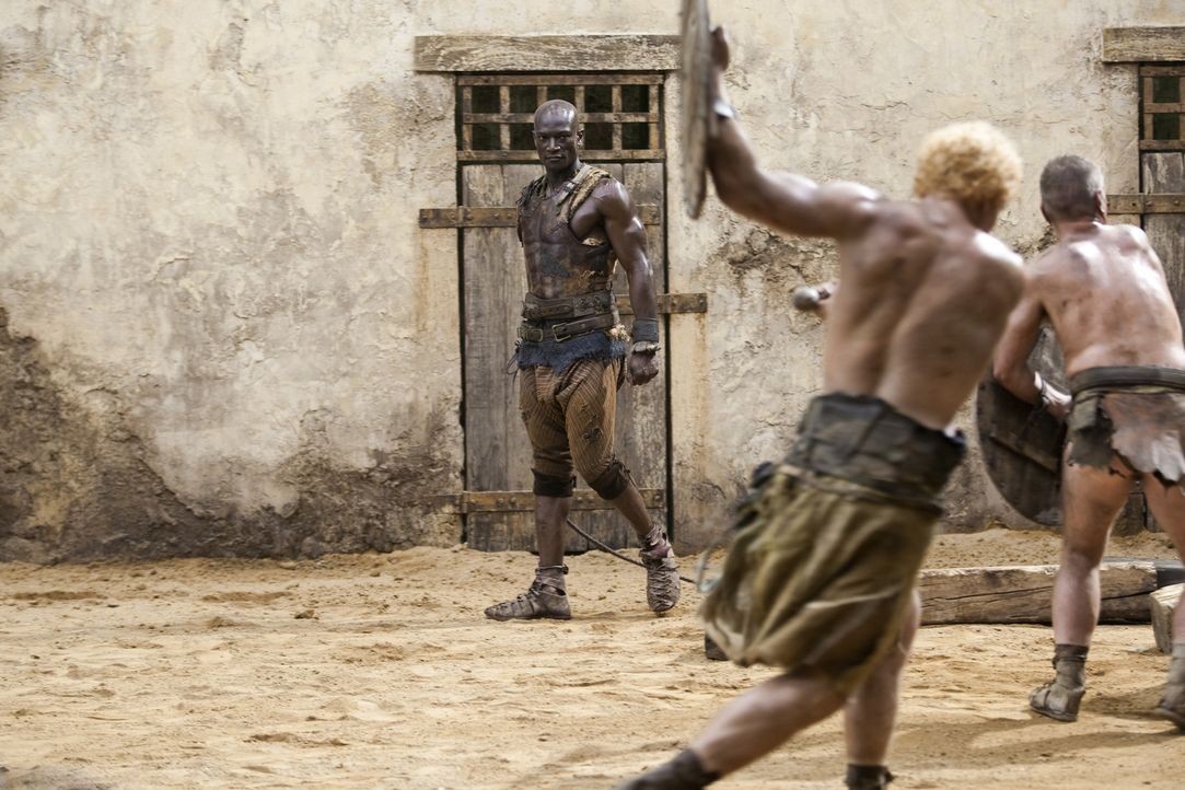 Der Trainer der Gladiatoren, Drago (Peter Mensah, hinten), muss ein strenges Regiment führen, damit seine Kämpfer überhaupt eine kleine Überlebe... - Bildquelle: 2010 Starz Entertainment, LLC